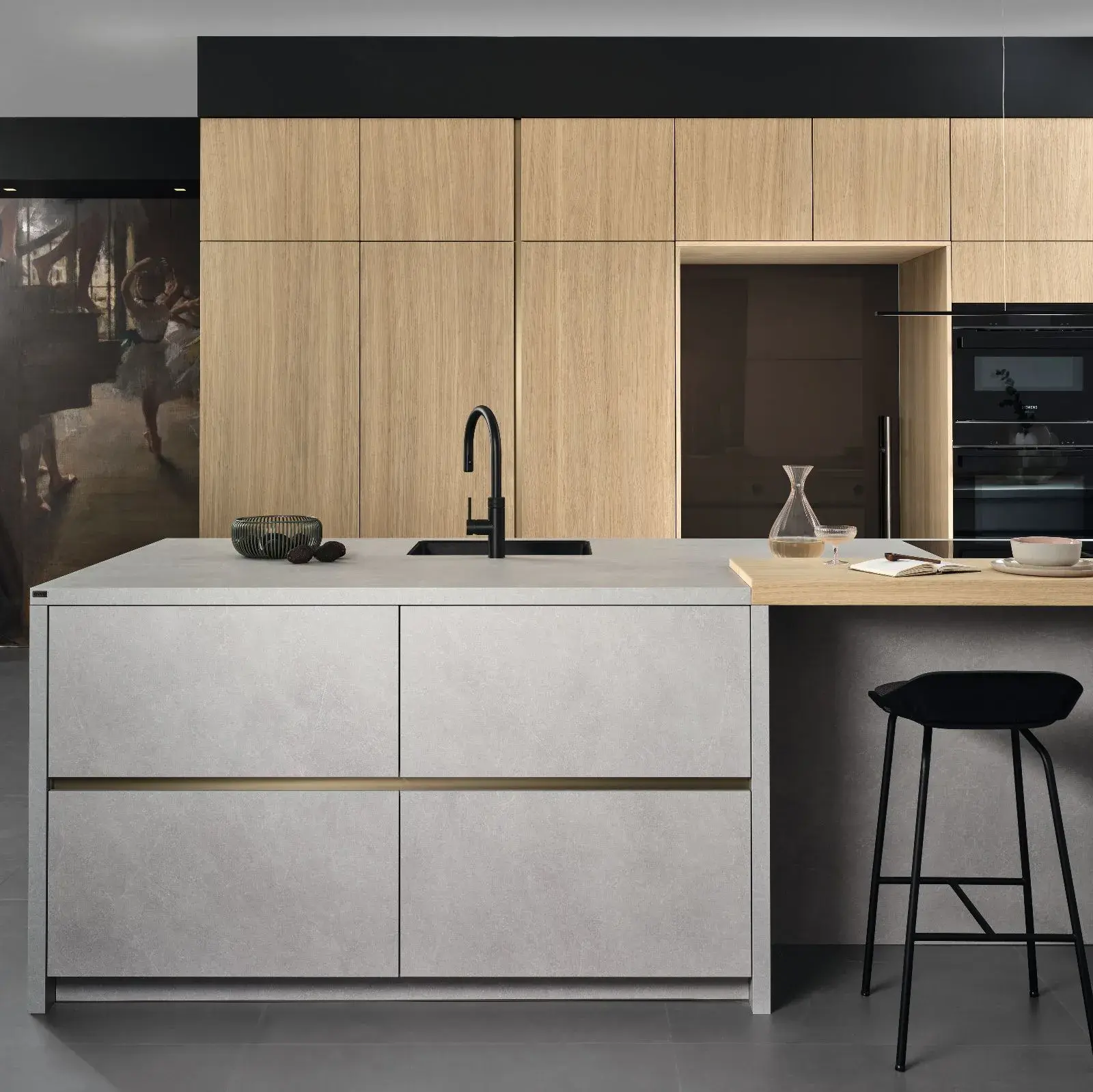 Moderne Küche mit hellem Holz, grauer Kochinsel und schwarzem Hocker.